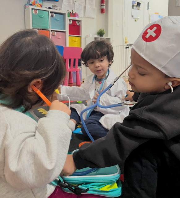 Children in doctor coats playing pretend check-up together